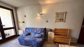 A bedroom with a large bed, wooden furniture, a small table, and a window with a view. - Studio for 4 pers at slopes' foot with south-facing balcony, parking (Corrençon-en-Vercors)