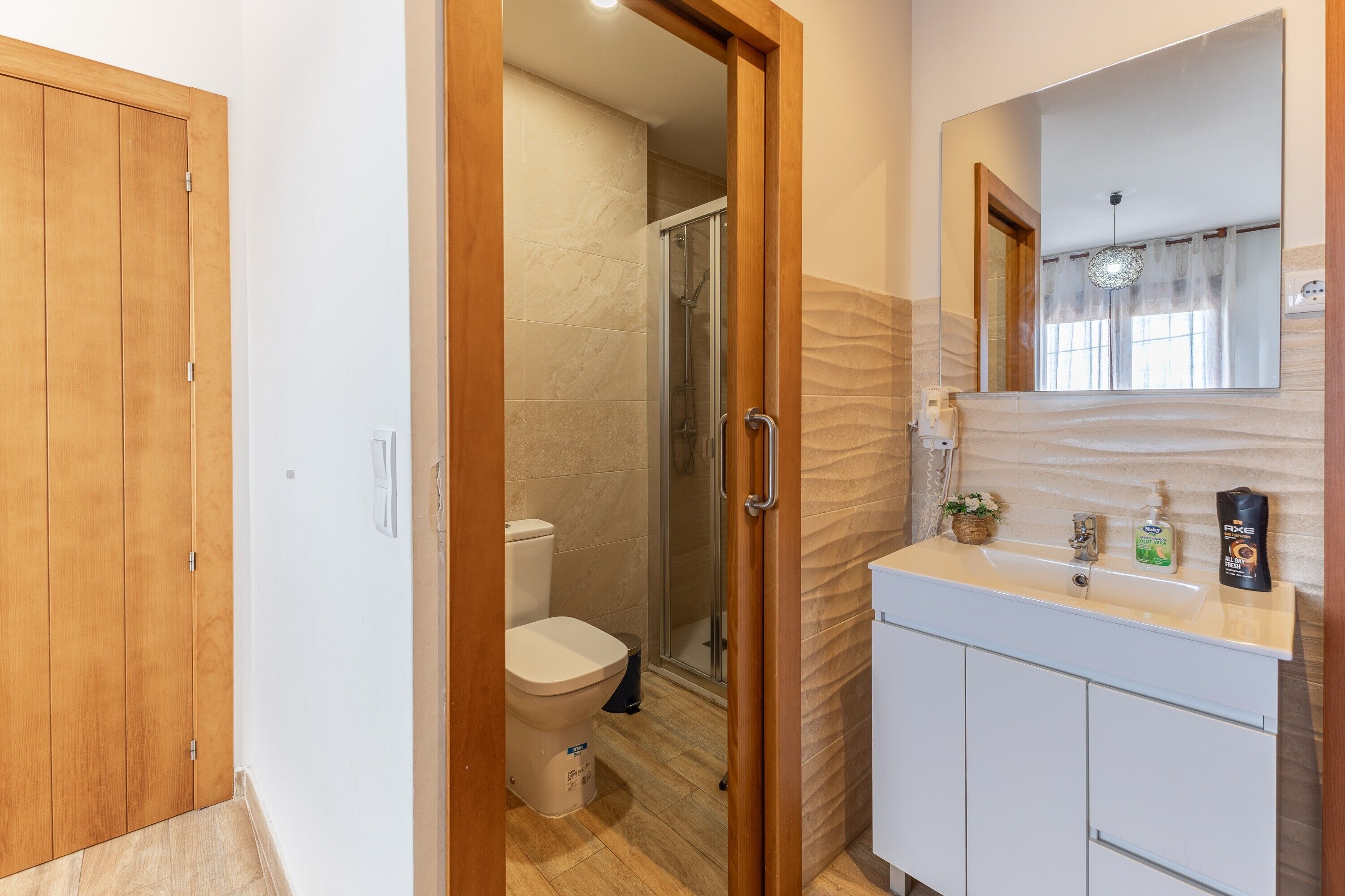 Et badeværelse med toilet, bruser og vask.