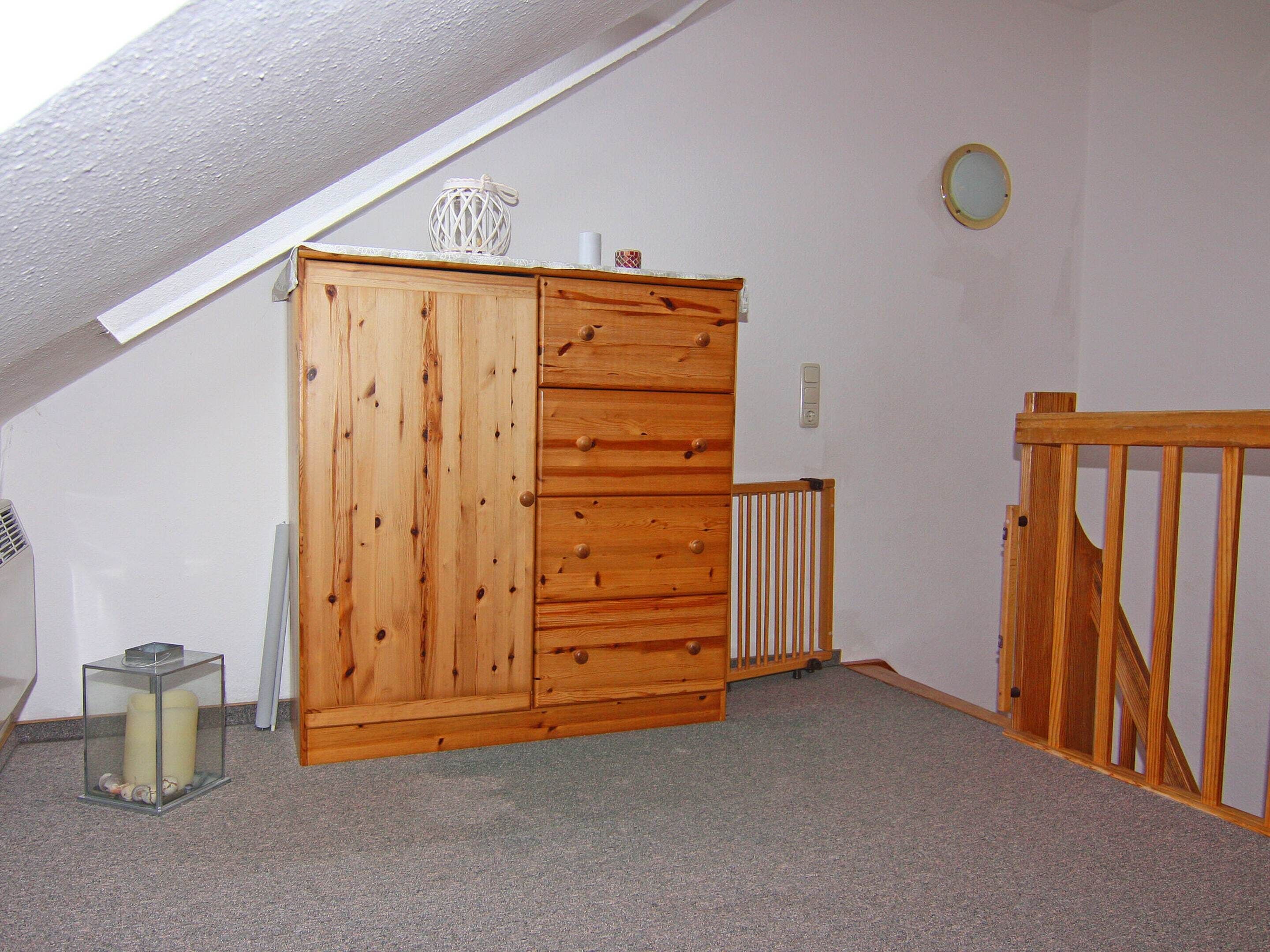 A room with a wooden cabinet, a radiator, and a glass display case with candles.