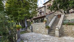 Ein steinerner Innenhof mit einer Treppe, die zu einem Gebäude mit Balkonen führt.