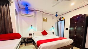 Ein Hotelzimmer mit einem großen Bett, einem Kleiderschrank, einem Nachttisch und einem Deckenventilator.