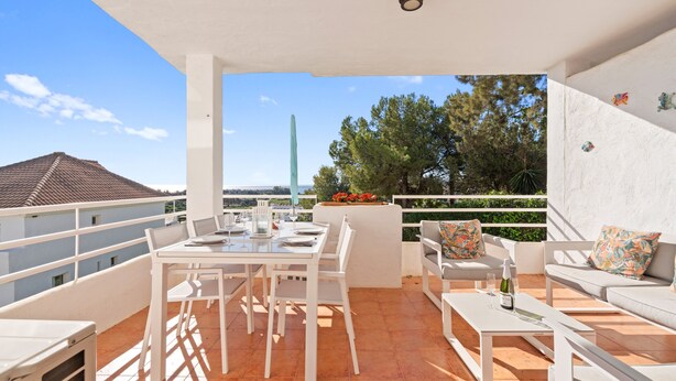 A terrace with a table and chairs, a sofa, and a view of trees and buildings. - Apartment 'Sea View Close To The Beach' with Private Pool, Wi-Fi and Air Conditioning (Málaga)