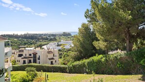 A residential area with a view of the sea, a large tree, and buildings with balconies. - Apartment 'Sea View Close To The Beach' with Private Pool, Wi-Fi and Air Conditioning (Málaga)