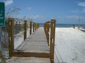 A wooden boardwalk leading to a sandy beach with a clear blue sky. - Affordable gulfside townhome (Port Saint Joe)