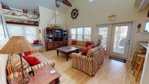 A cozy living room with striped sofas, a wooden coffee table, and a television.