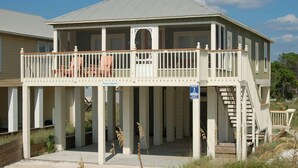 A two-story house with a balcony, a staircase, and a porch. - Gulf View Beach Cottage across from beach access (Port Saint Joe)