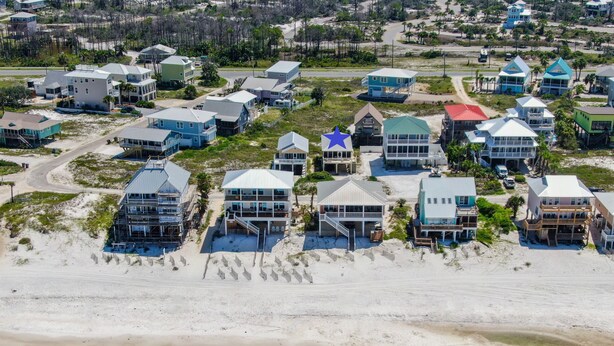 A coastal residential area with houses featuring balconies and direct beach access. - Gulf View Beach Cottage across from beach access (Port Saint Joe)
