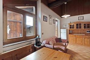 Une pièce chaleureuse avec une table en bois, un canapé, une machine à café et un meuble.