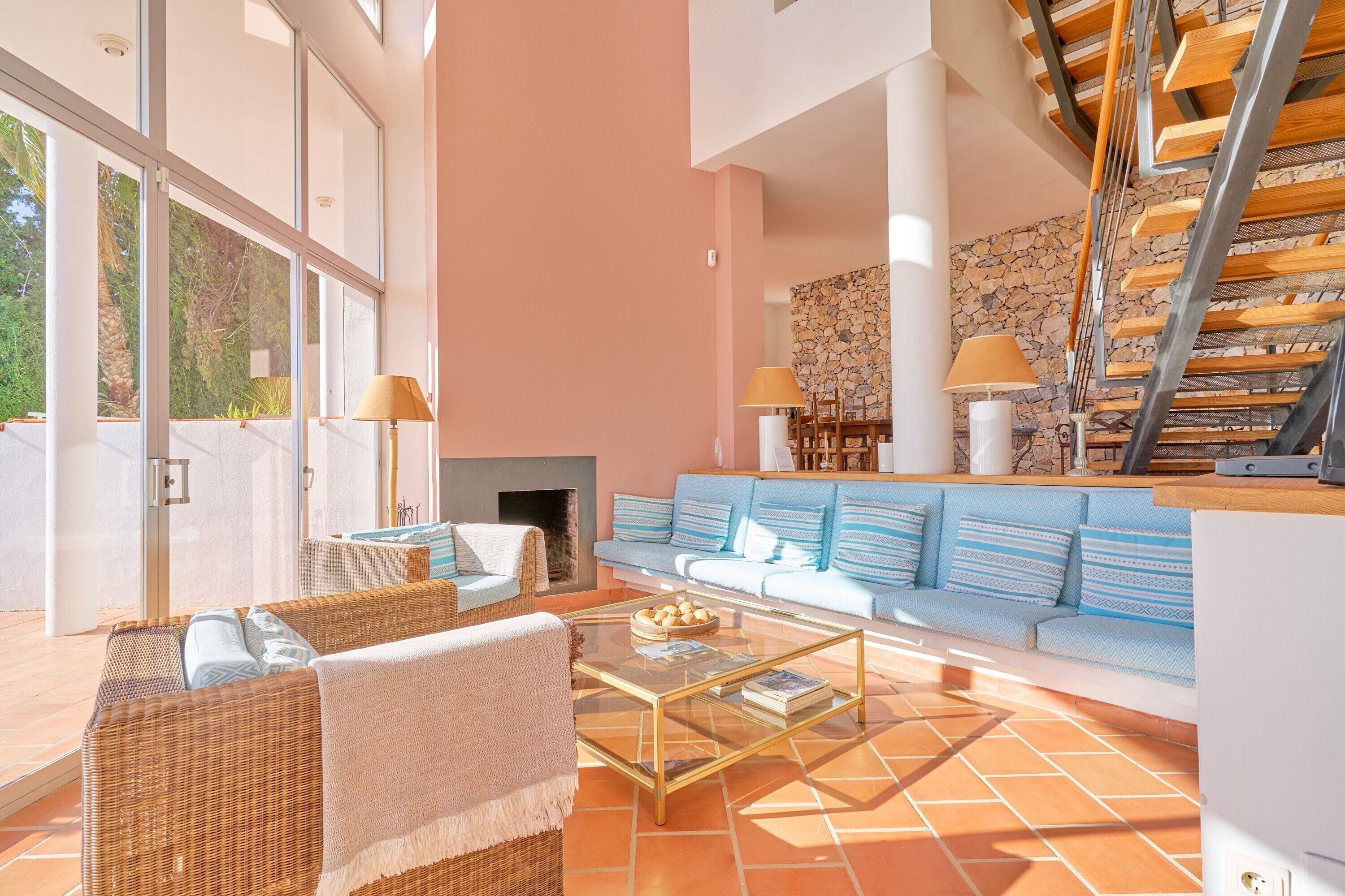 A spacious living area with a large sofa, a coffee table, and a fireplace.