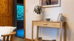 Een houten stoel en een klein houten tafeltje met een fotolijst en decoratieve objecten.