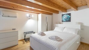A bedroom with a bed, a bedside table, a wardrobe, and an air conditioning unit. - Italianway - Isonzo 24 (Milan)