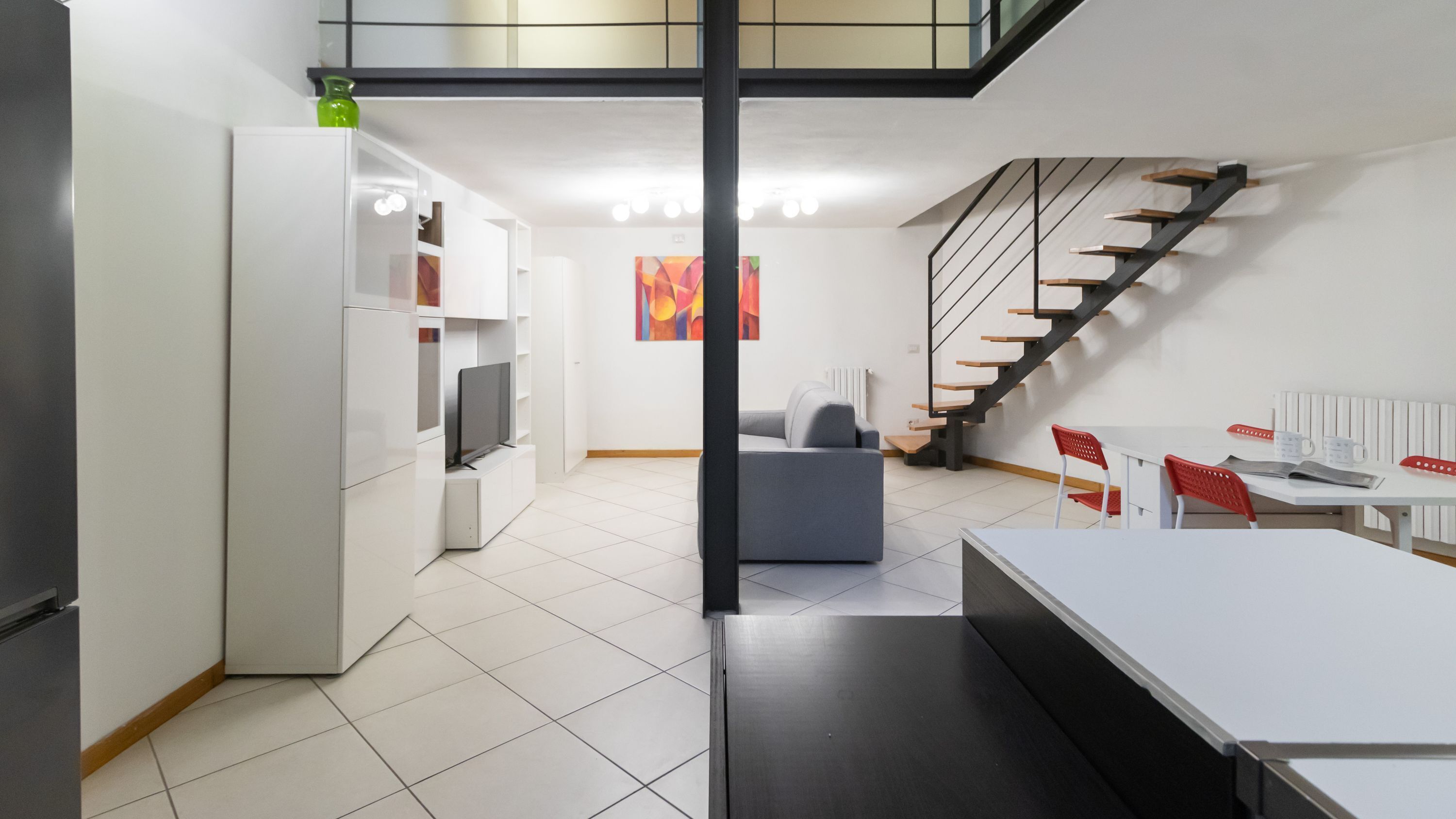 A modern interior with a staircase, a dining area, and a living space.