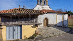 A building with a bell tower, a cobblestone courtyard, and a wooden door. - Room 'Habitacion 3' with Mountain View, Wi-Fi and Air Conditioning (Asturias)