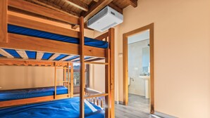 A bunk bed room with a wooden ceiling, a bathroom with a sink, and a view of the outside. - Room 'Habitacion 3' with Mountain View, Wi-Fi and Air Conditioning (Asturias)