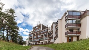 Un immeuble résidentiel à plusieurs étages, doté de balcons et de grandes fenêtres.