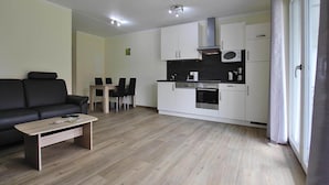 A modern apartment with a living area, dining space, and kitchen. - Appartement Hafenflair am Plauer See (Plau am See)