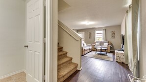 Ein geräumiges Wohnzimmer mit einer Couch, einem Couchtisch und einer Treppe, die in einen anderen Bereich führt.