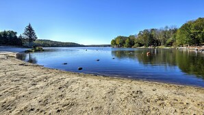 A calm lake with a sandy shore, surrounded by trees and hills. - Family Friendly: Streamside Retreat in The Hideout (Lake Ariel)