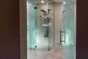 A modern glass-enclosed shower area with a glass door, a handheld showerhead, and a wall-mounted control panel. - 6 Mi to DC To-dos: Large Family Bethesda Home! (Bethesda)
