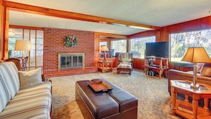 A cozy living room with a fireplace, comfortable seating, and a television. - 6 Mi to Manatee Springs! Family Riverfront Getaway (Chiefland)