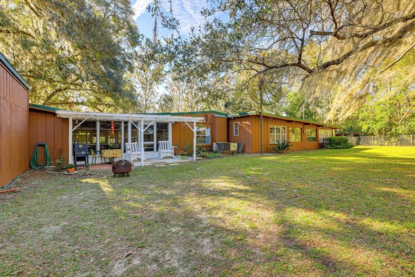 A wooden house with a covered porch, a fenced yard, and a large tree with Spanish moss. - Suwannee River Escape: 6 Mi to Manatee Springs (Chiefland)