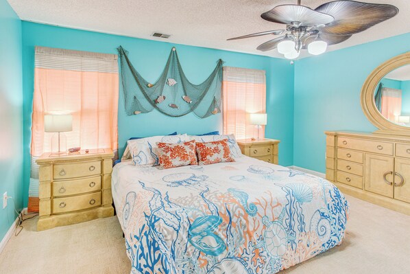 A bedroom with a bed, two nightstands, a dresser, a ceiling fan, and a large mirror. - 3 Mi to Ocean: Home w/ Deck in Little River! (Little River)