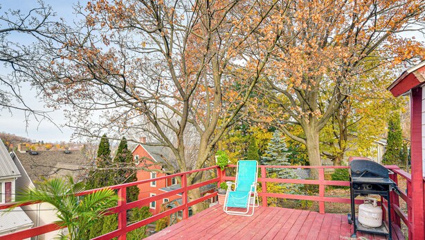 A red deck with a blue lounge chair, a potted plant, and a propane tank. - Bethlehem Home w/ Patio & Amazing Sunset Views! (Bethlehem)