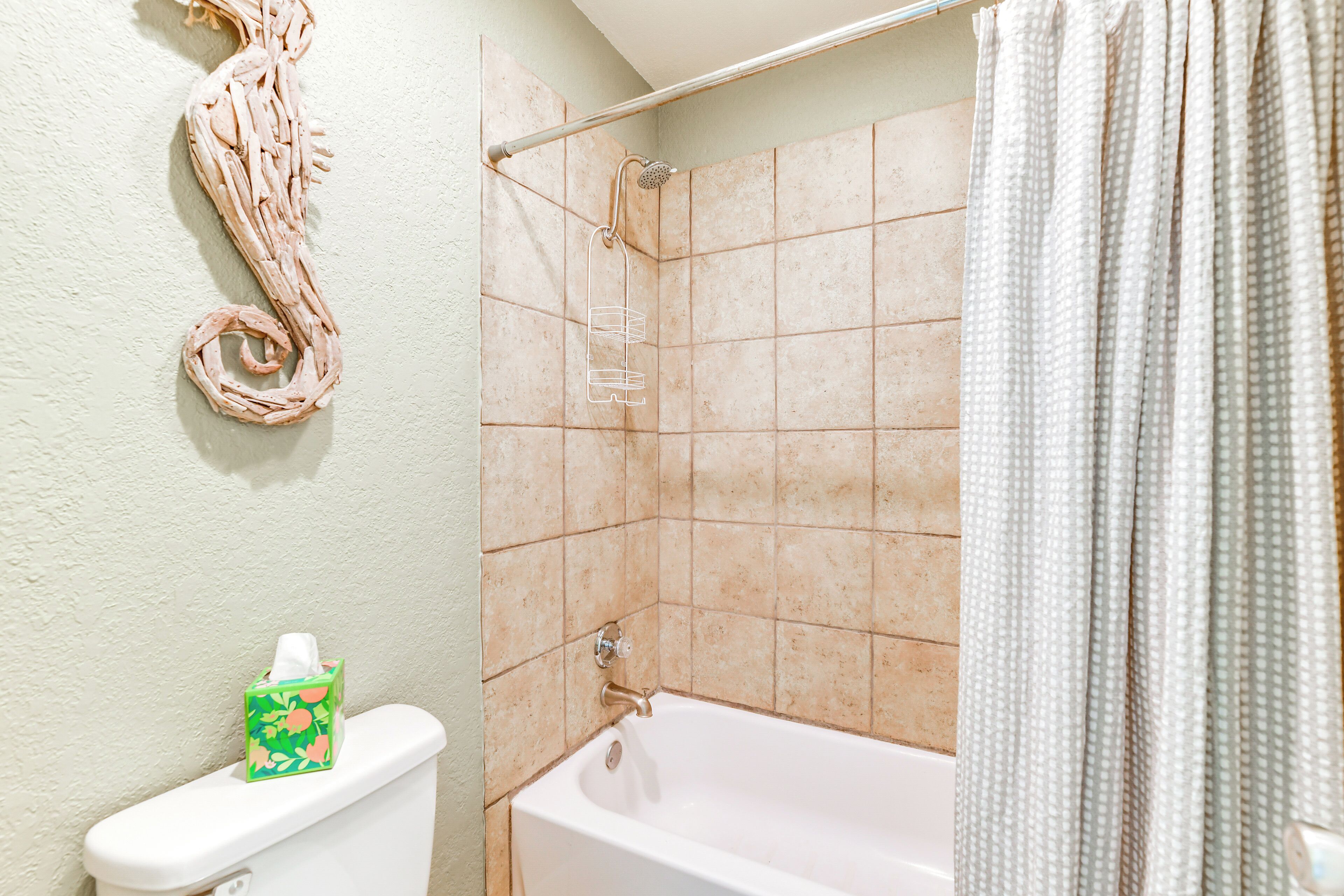 Une salle de bain équipée de toilettes, d’une douche et d’une baignoire.