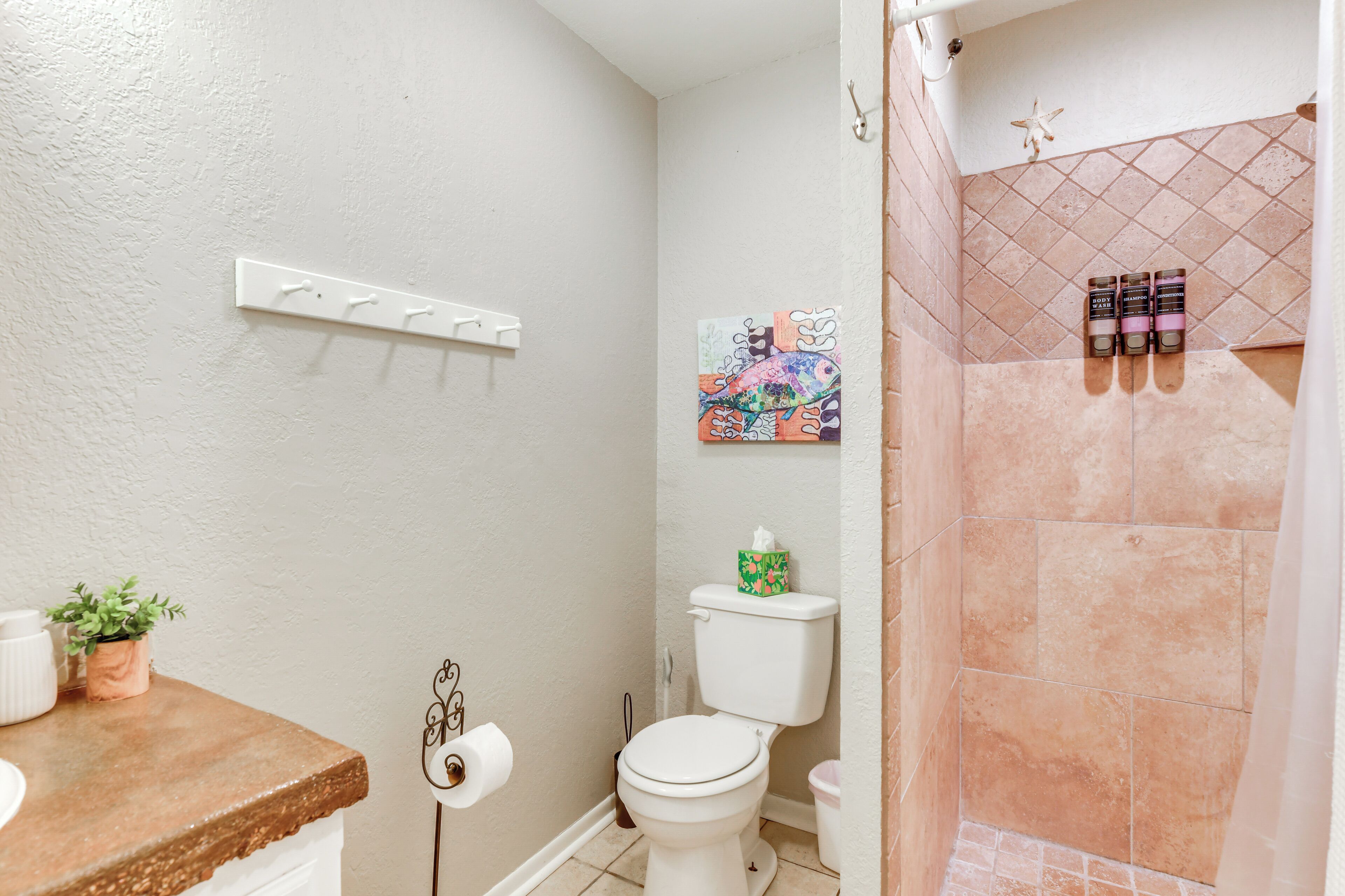 Un baño con inodoro, lavabo y zona de ducha.