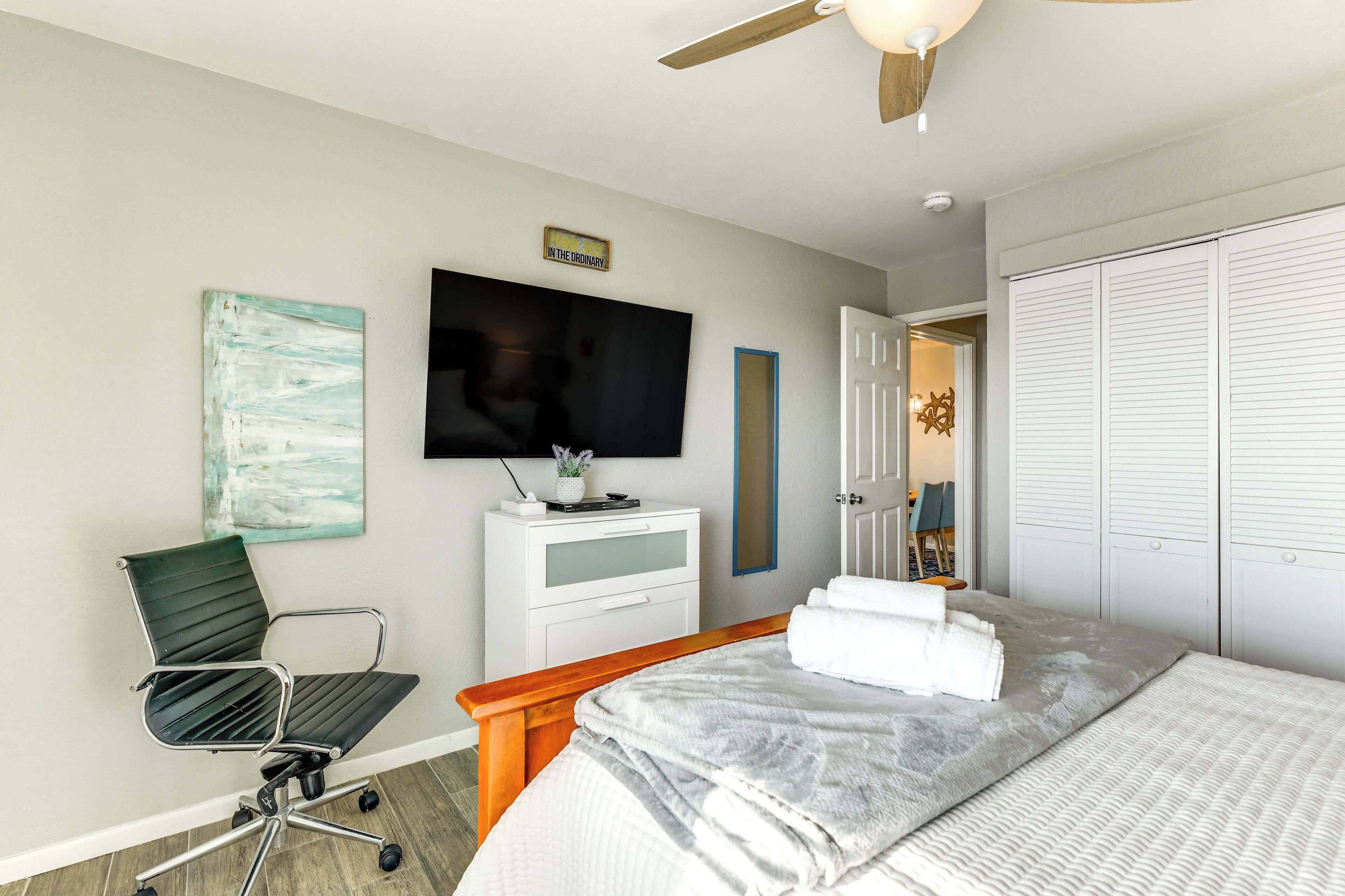 Ein Hotelzimmer mit Bett, Schreibtisch mit Stuhl, Fernseher und Kleiderschrank.