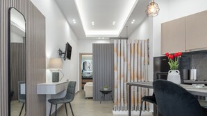 Une cuisine moderne avec un coin repas, un téléviseur et un paravent décoratif en bambou.