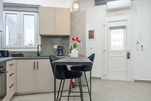 Une cuisine moderne avec une table à manger, des chaises et un vase de tulipes rouges.