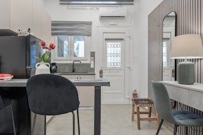 A modern kitchen with a black refrigerator, a sink, a window, and a door with a window.