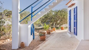 A white building with blue accents, a staircase, and potted plants. - Holiday Home 'Casa Del Sol' with Sea View, Private Terrace and Wi-Fi (Illes Balears)