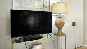 A flat-screen TV on a glass-top console with a lamp beside it. - Sublim and new Apartment Center of Paris / Opera (Paris)