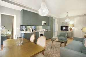 A modern living room with a dining table, chairs, a sofa, and a TV. - Sublim and new Apartment Center of Paris / Opera (Paris)