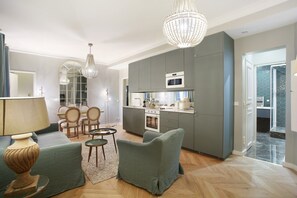 Un soggiorno moderno con un divano, poltrone, un tavolino da caffè e un lampadario.