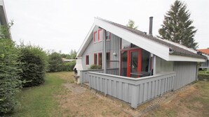 A two-story house with a balcony, a chimney, and a garden. - Ferienhaus im Ferienpark Mirow (Mirow)