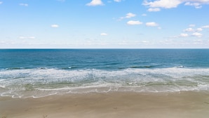 Una playa con cielo despejado y mar tranquilo.
