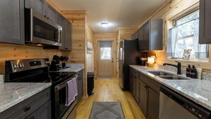 Eine moderne Küche mit Granit Arbeitsplatten, Edelstahlgeräten und Holzschränken.