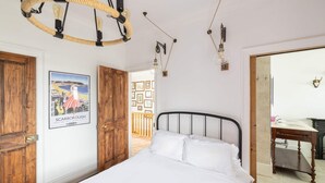 A bedroom with a bed, wooden wardrobe, and a poster of Scarborough. - Host Stay Ranworth (Scarborough)
