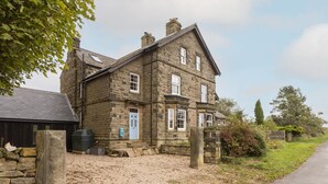 A stone house with a blue door, a gravel driveway, and a stone wall. - Host Stay Ranworth (Scarborough)