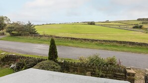 A rural landscape with a stone wall, a road, and green fields. - Host Stay Ranworth (Scarborough)