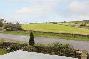 A rural landscape with a stone wall, a road, and green fields. - Host Stay Ranworth (Scarborough)
