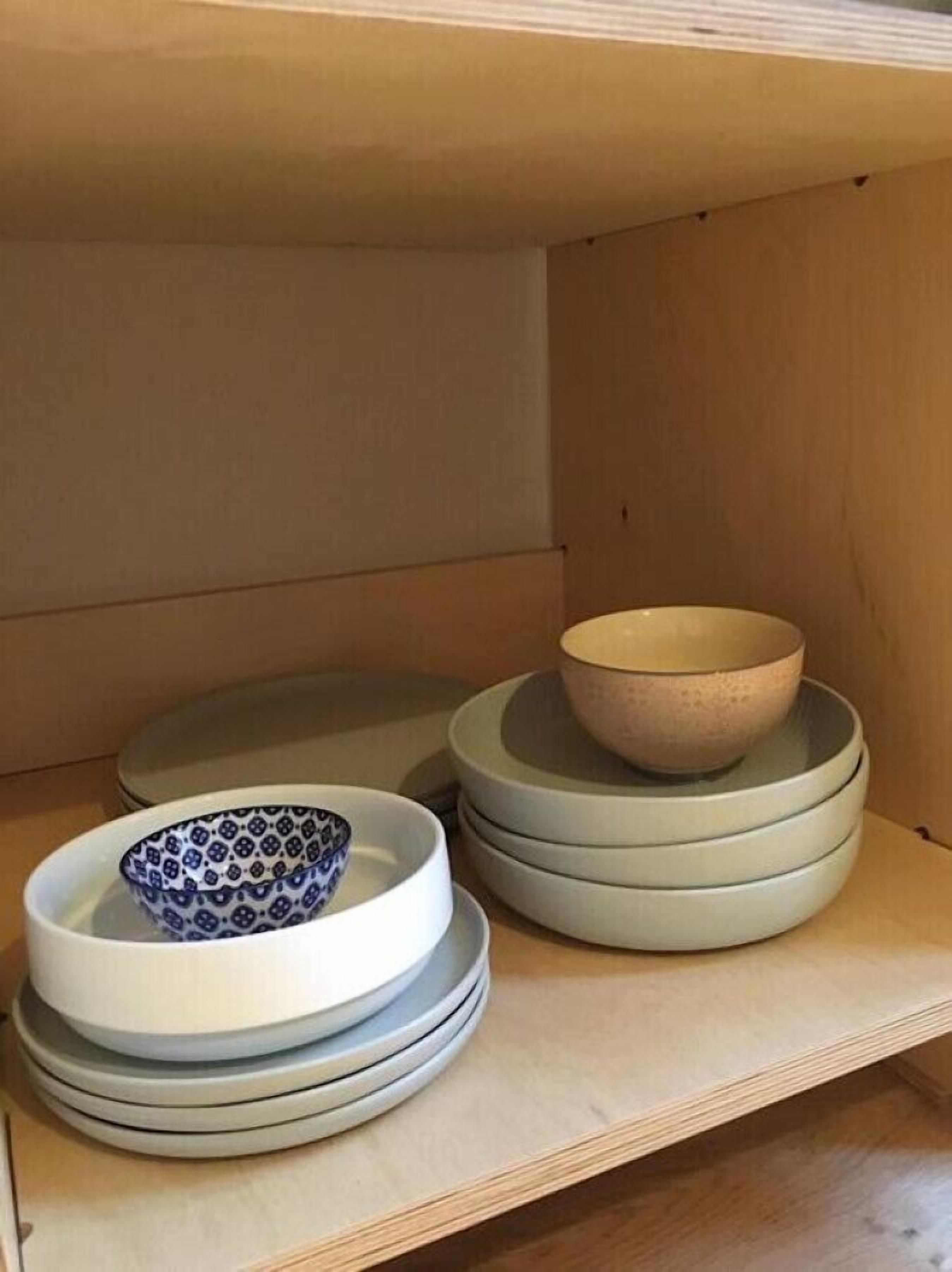 Een houten plank met gestapelde kommen en borden.