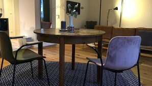 A round dining table with chairs, a vase with flowers, and a painting on the wall. - Arbio I Lax Attic Studio in Lindenau (Leipzig)