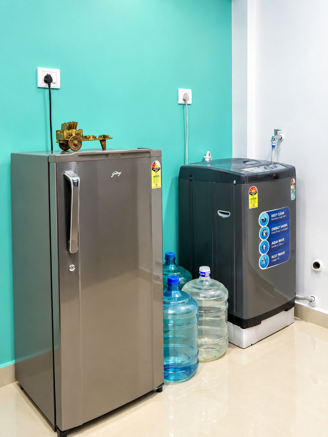 A stainless steel refrigerator and a water dispenser with water bottles on a tiled floor.