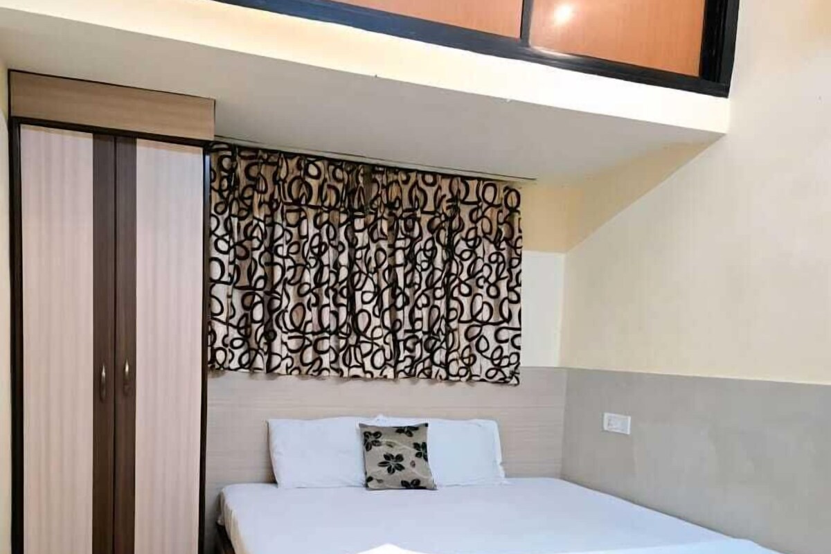 Une chambre à coucher comprenant un lit, une table en verre, une tête de lit à motifs et une armoire.