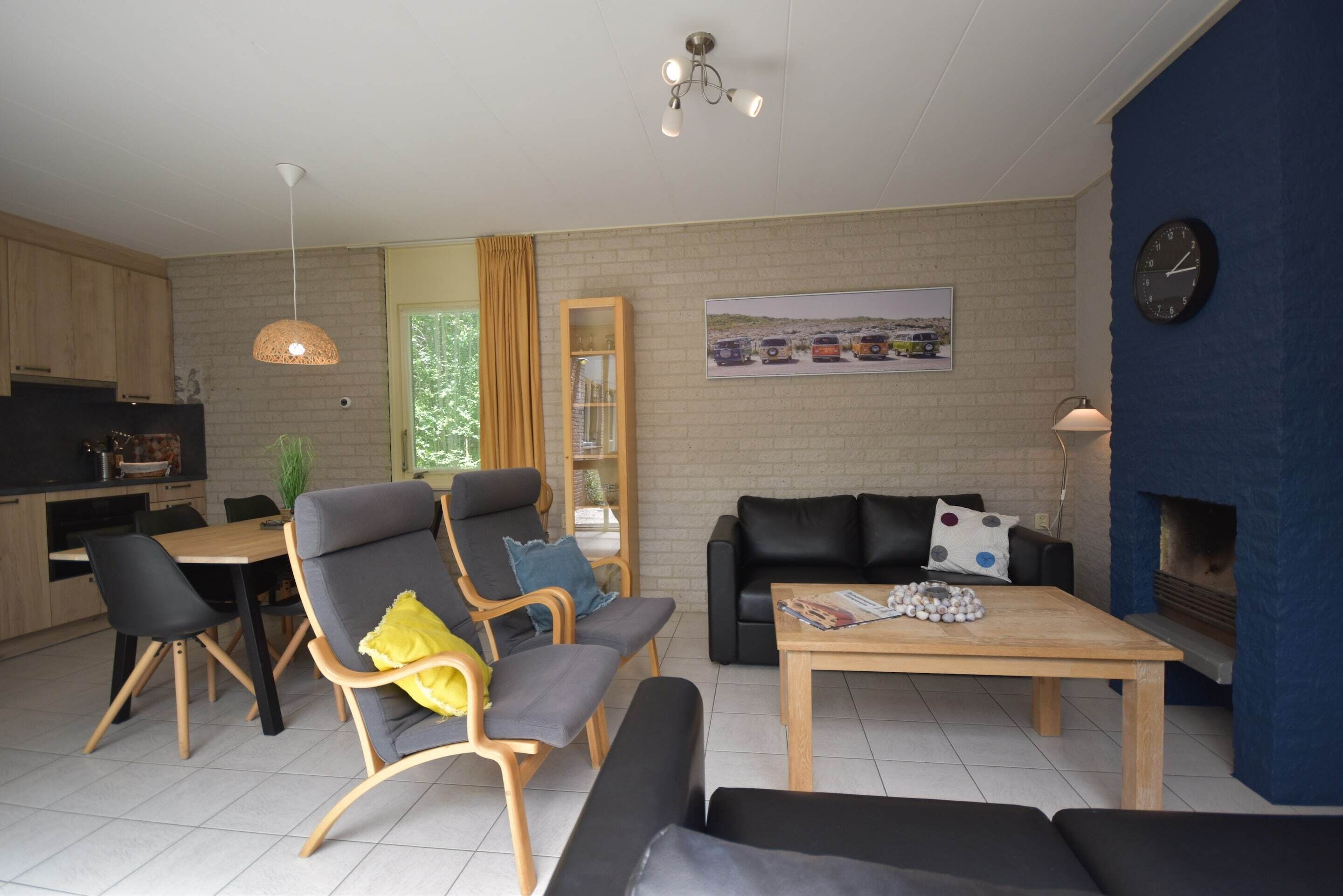 A modern living room with a sofa, armchairs, a coffee table, and a fireplace.