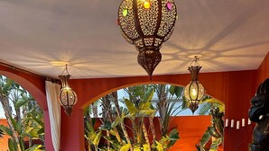 A lounge area with wicker furniture, a wooden coffee table, and decorative lamps. - RED-HOUSE, Red-House Tenerife Sur (Costa Adeje)